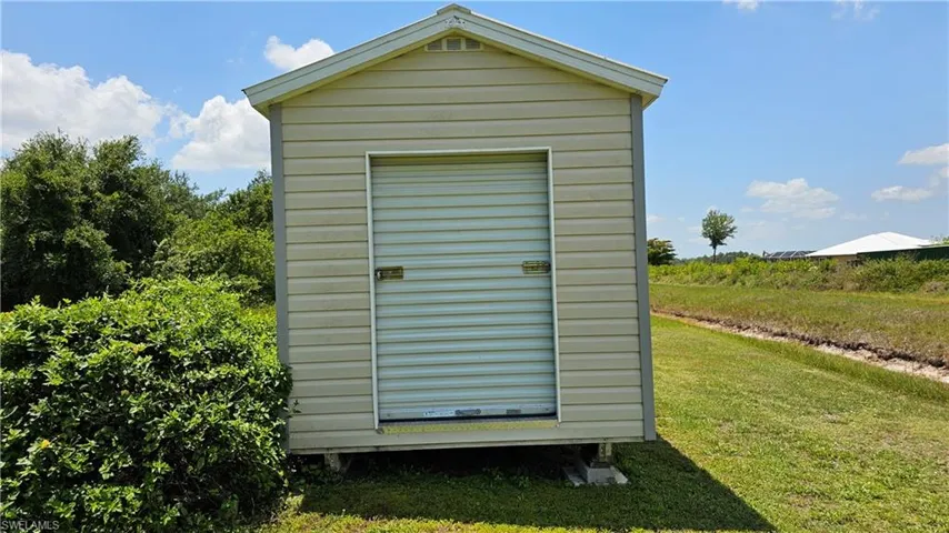 View of outbuilding with a lawn