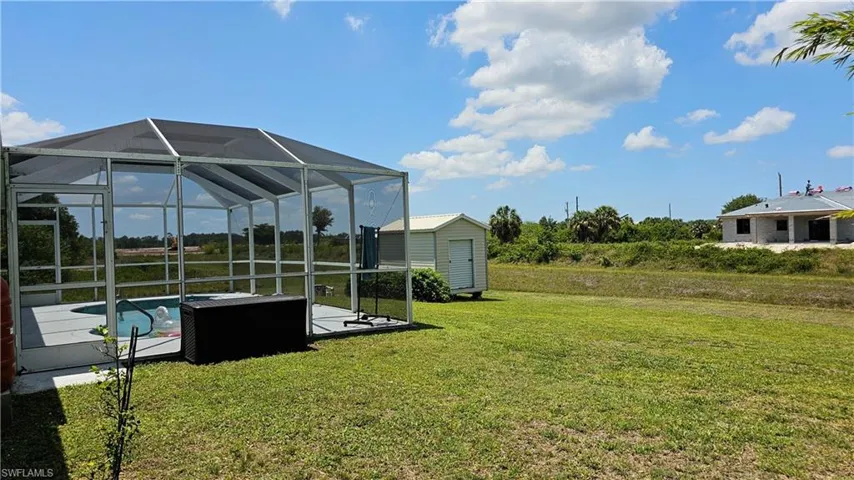 View of yard with glass enclosure and a storage shed