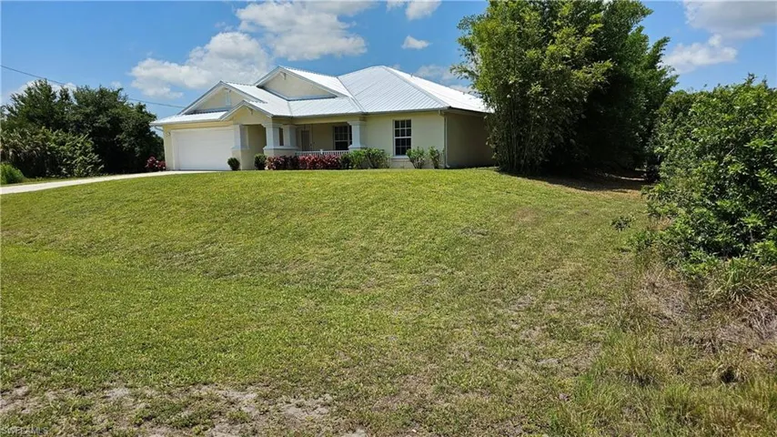 View of front of home with a front lawn and a garage