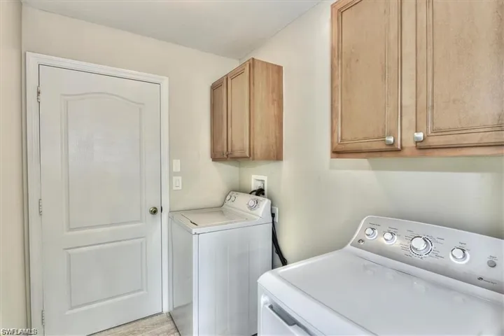 Laundry room featuring washer and clothes dryer and cabinets