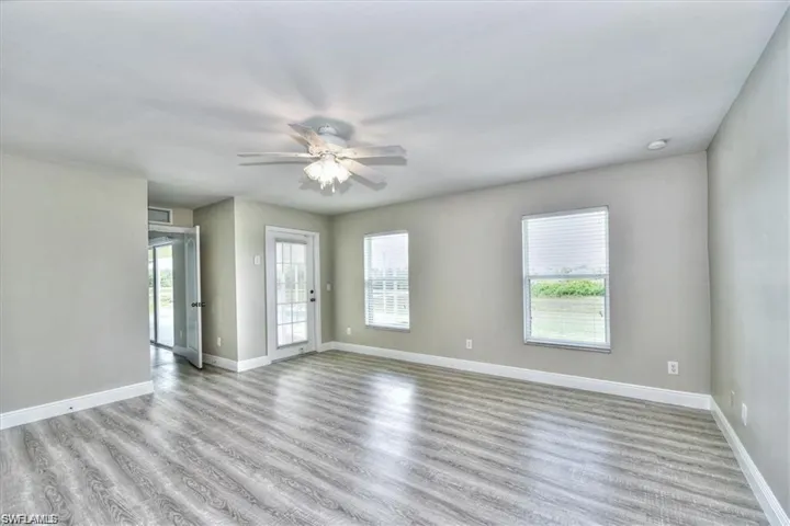 Empty room featuring ceiling fan, a wealth of natural light, and light hardwood / wood-style flooring