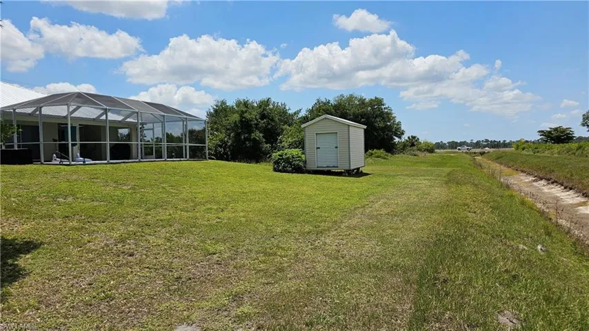 View of yard with a lanai and a storage unit