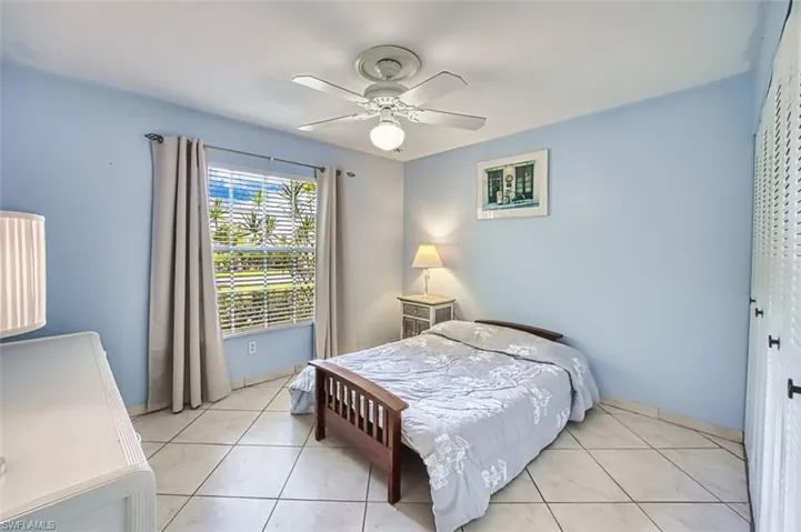 Bedroom featuring light tile patterned floors, a closet, and ceiling fan