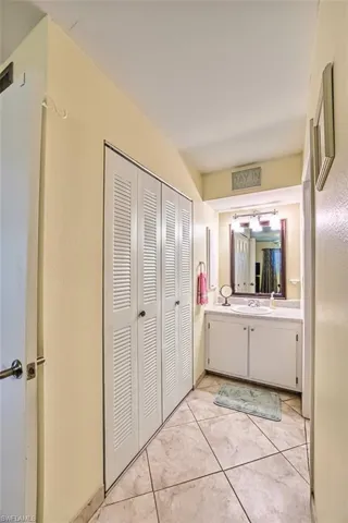 Bathroom featuring vanity, light tile patterned flooring, and a closet
