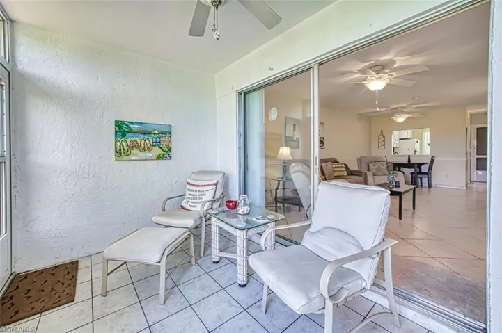 Sunroom featuring a ceiling fan and glass