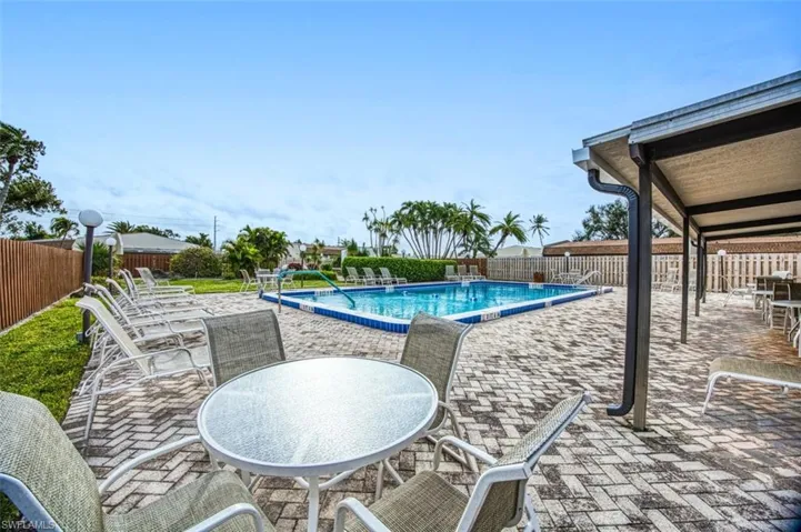 Community pool featuring a patio and a fenced backyard