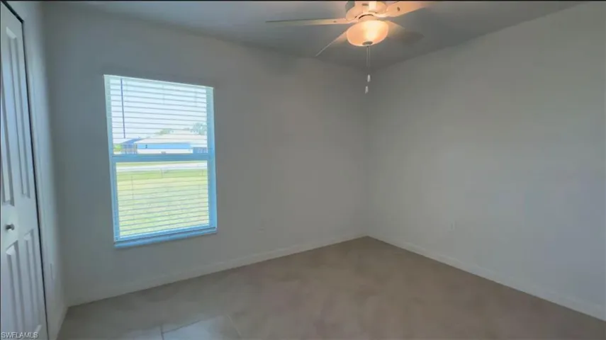 Unfurnished room with baseboards and a ceiling fan