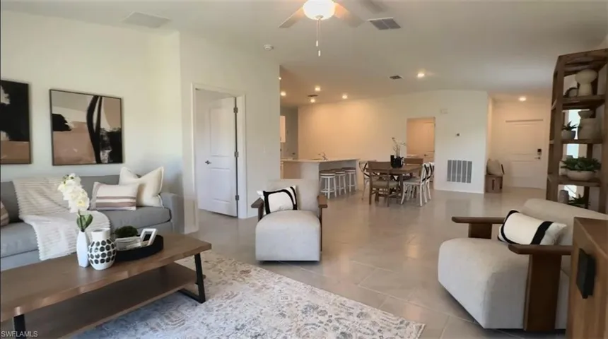 Living room featuring a ceiling fan, recessed lighting, and light tile patterned flooring