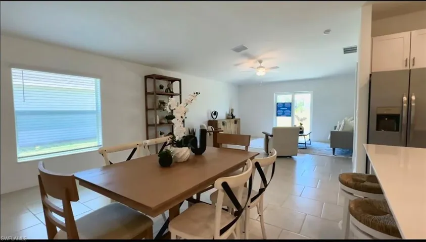 Dining area with light tile patterned floors and ceiling fan