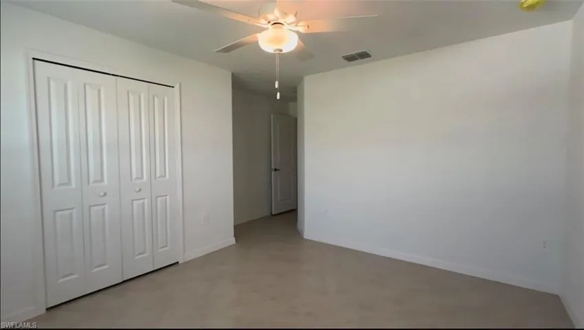 Unfurnished bedroom with a ceiling fan and a closet