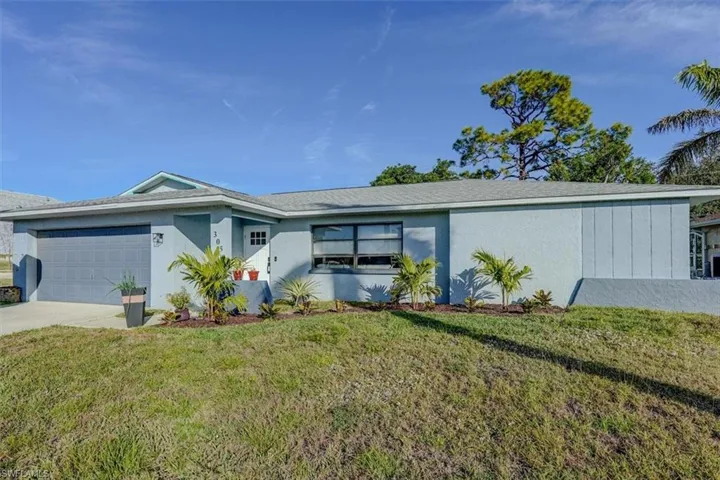 Ranch-style home with a garage and a front lawn