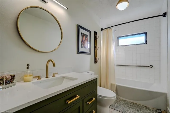 Full bathroom with vanity, tile patterned flooring, toilet, a textured ceiling, and shower / tub combo with curtain