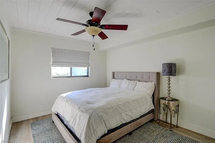 Bedroom featuring ceiling fan, crown molding, wood-type flooring, and wooden ceiling