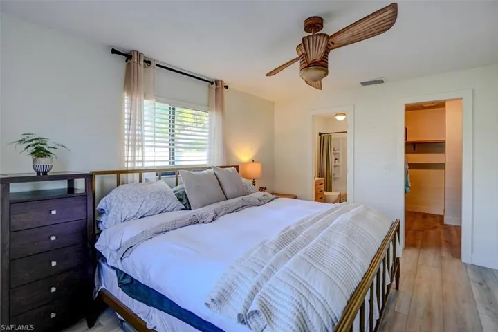 Bedroom featuring a walk in closet, ceiling fan, connected bathroom, light hardwood / wood-style floors, and a closet