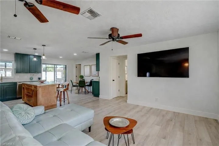 Living area featuring light wood-style floors, a ceiling fan, and a textured ceiling