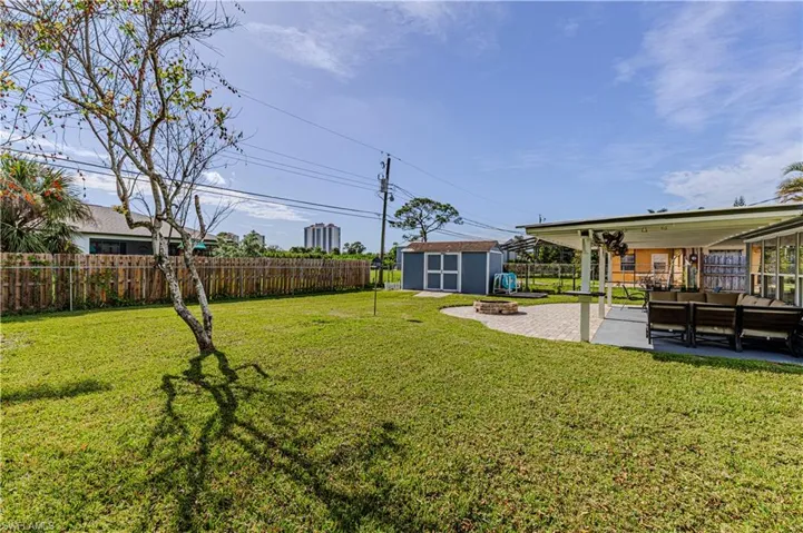 View of yard with a patio, a shed, and an outdoor fire pit