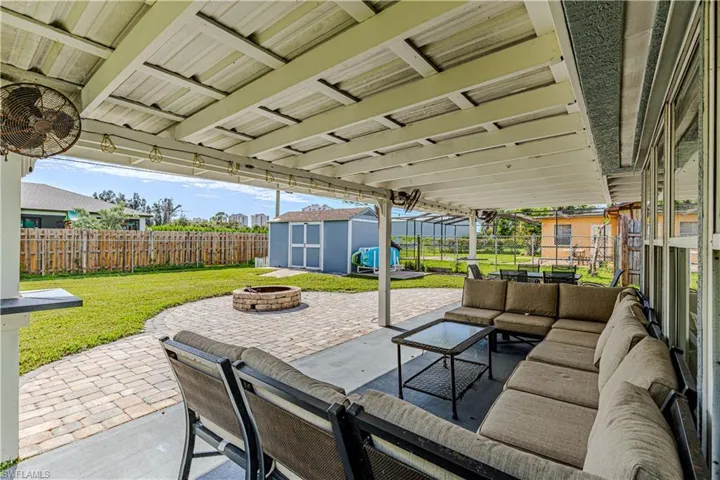 View of patio with an outdoor living space with a fire pit, a storage shed, and ceiling fan