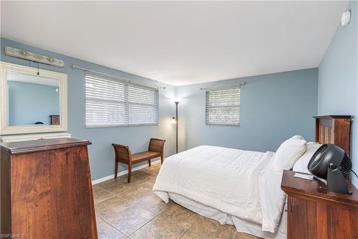 Tiled bedroom featuring multiple windows