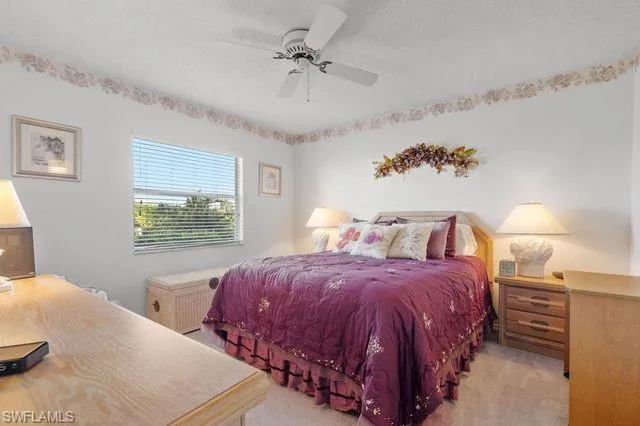 Carpeted bedroom featuring ceiling fan