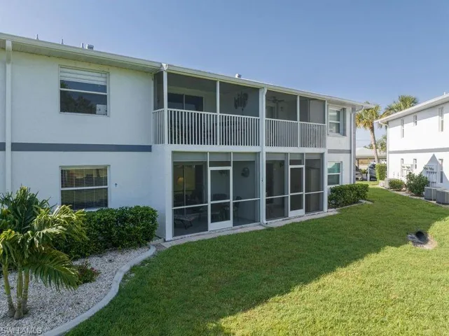 Rear view of property with a yard, a balcony, and central air condition unit