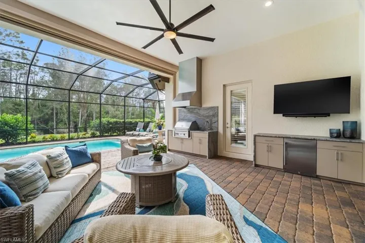 View of patio with a lanai, area for grilling, an outdoor living space, exterior kitchen, and an outdoor pool