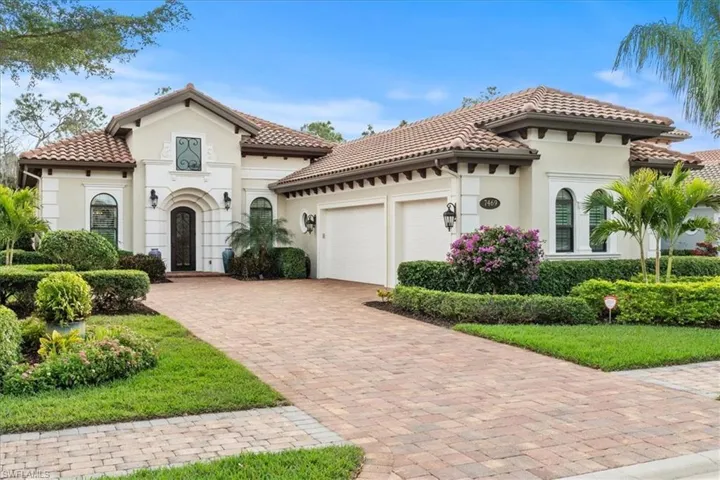 Mediterranean / spanish home featuring an attached garage, a tiled roof, decorative driveway, and stucco siding