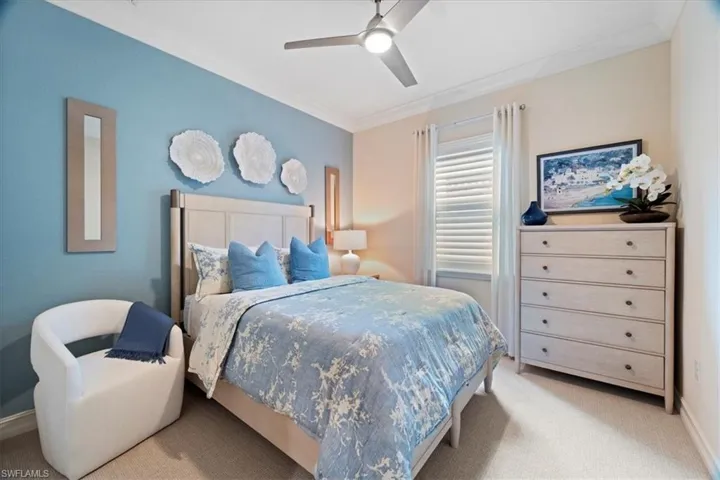 Bedroom featuring crown molding, ceiling fan, baseboards, and light colored carpet