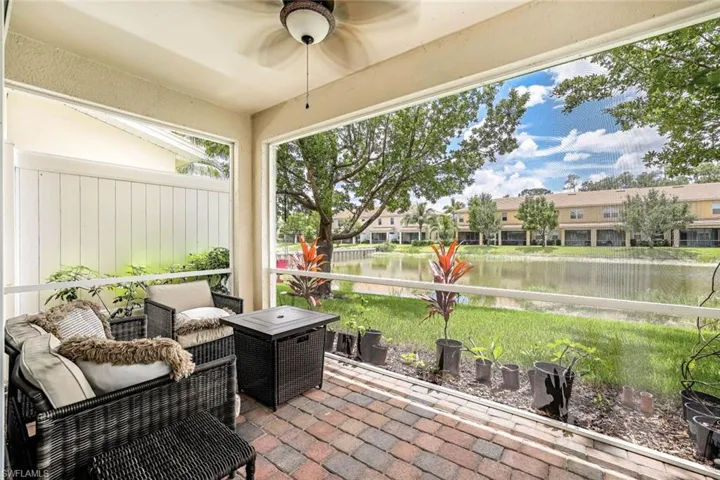 Sunroom / solarium with ceiling fan and a water view