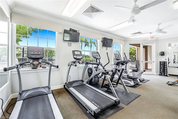 Exercise room with a wealth of natural light, ceiling fan, and ornamental molding