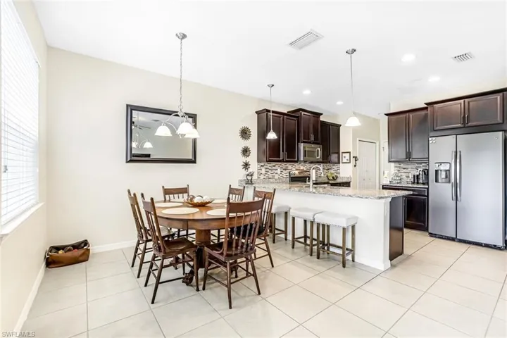 Dining room featuring light tile patterned floors, sink, and a notable chandelier