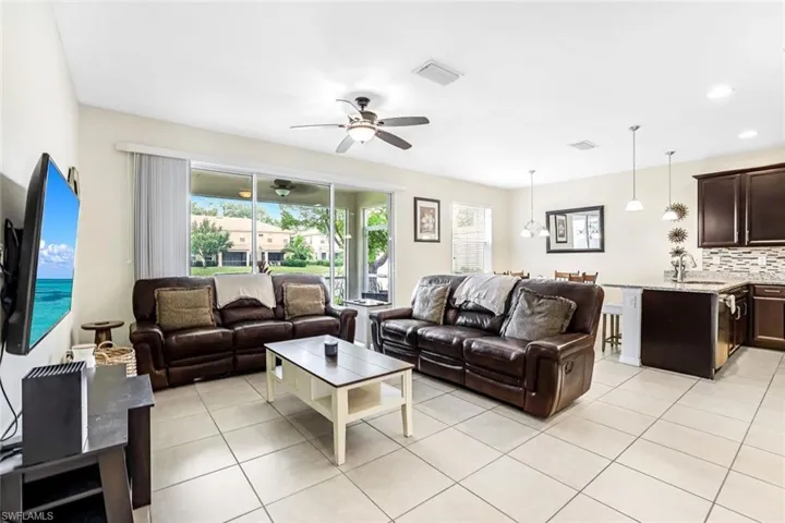 Living room featuring ceiling fan, sink, and light tile patterned floors
