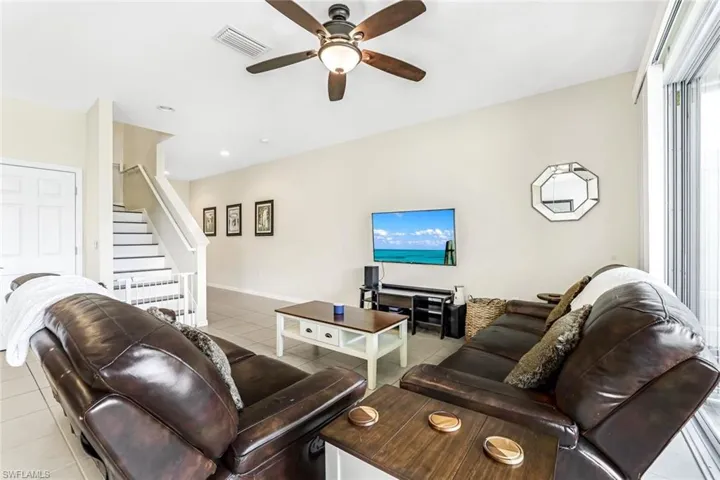 Tiled living room featuring ceiling fan