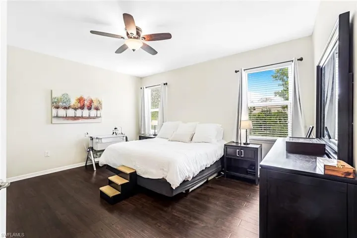 Bedroom with ceiling fan and dark hardwood / wood-style flooring