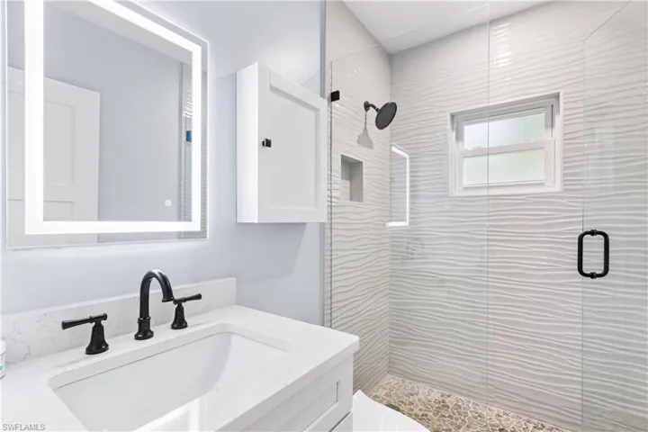 Bathroom featuring a shower stall, vanity, and toilet