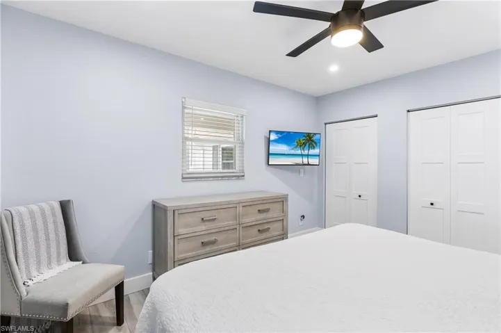 Bedroom featuring ceiling fan, baseboards, multiple closets, recessed lighting, and wood finished floors