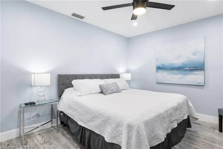 Bedroom featuring visible vents, baseboards, a ceiling fan, and light wood finished floors