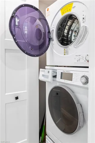 Washroom with laundry area and stacked washing maching and dryer