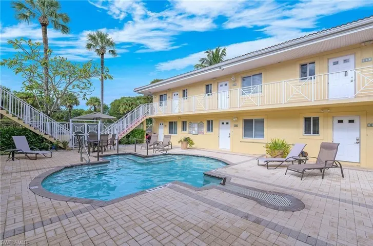 Community pool featuring stairs, a patio, and a balcony
