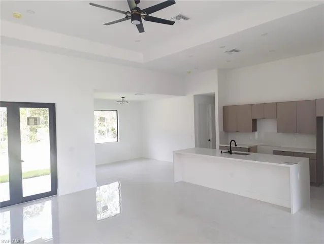 Kitchen with sink, ceiling fan, and an island with sink