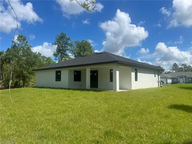 Rear view of property with a yard