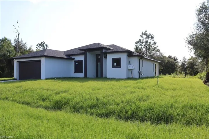View of front of house featuring a garage and a front lawn
