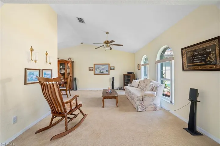 Kitchen featuring white appliances, ceiling fan,  tile floors, white cabinetry, and a tray ceiling