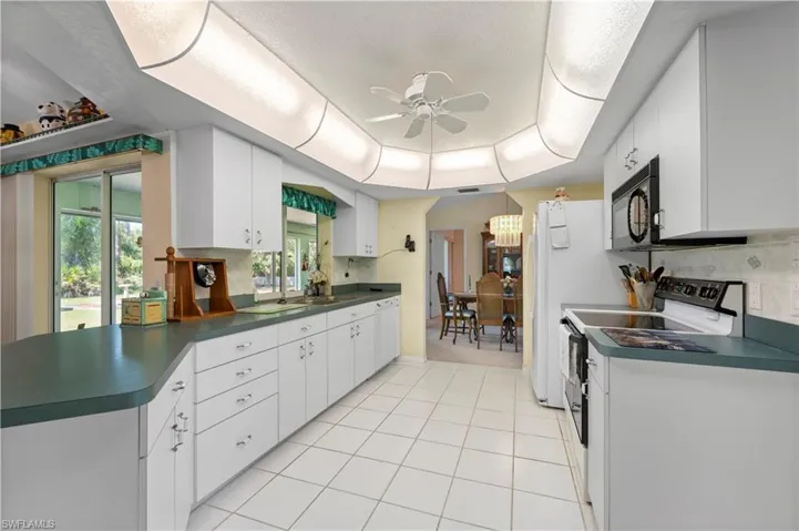 Bedroom featuring access to Sun Room, ceiling fan, and a textured ceiling
