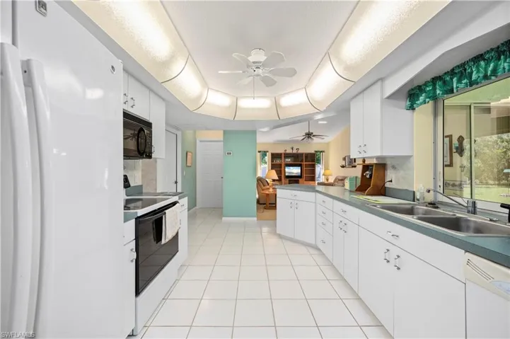Family Room with lofted ceiling, a ceiling fan, and light tile patterned floors