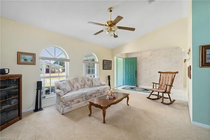 Kitchen featuring electric range oven, a ceiling fan, black microwave, light tile floors, beautiful lighting and ceiling fan.