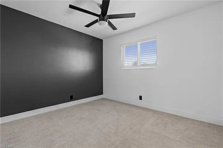 Spare room with light colored carpet and ceiling fan