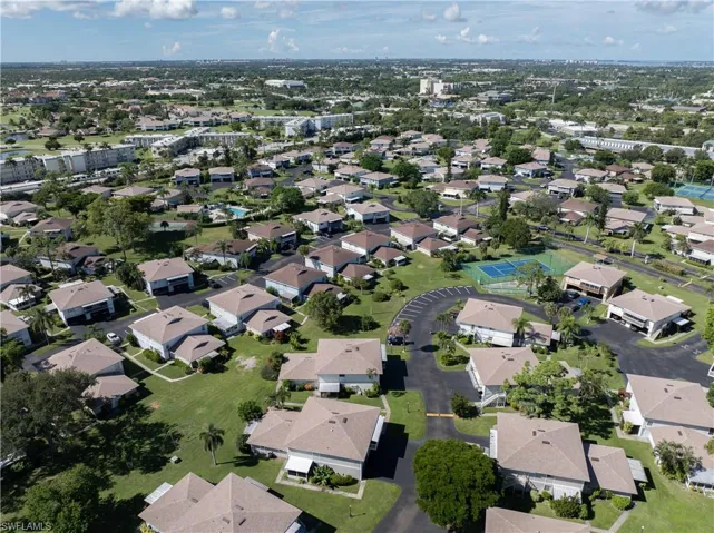 Aerial view of property and surrounding area featuring nearby suburban area