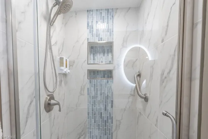 Full bath featuring a marble finish shower