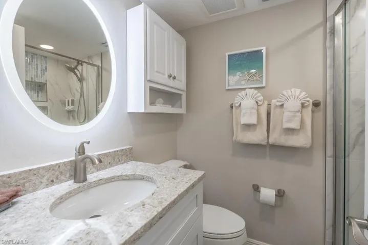 Full bath with a marble finish shower and vanity