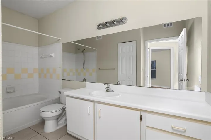 Bathroom featuring shower / washtub combination, vanity, and light tile patterned floors